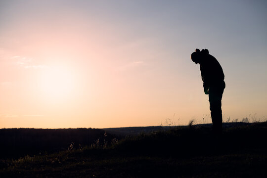 Silhouette Bowing in Reverence to the Setting Sun