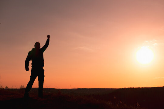 Fist Raised in Defiance Against the Sunset Sky