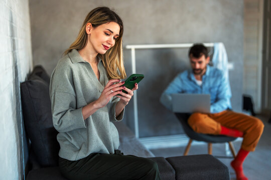 Cheerful caucasian couple enjoying digital communication and social interaction, they relax at home