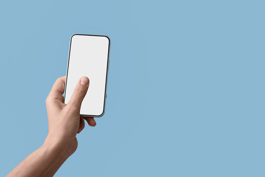 Hand holding a modern smartphone with a blank white screen for app display on a light blue background, the device is presented against a light blue background, ideal for mobile applications