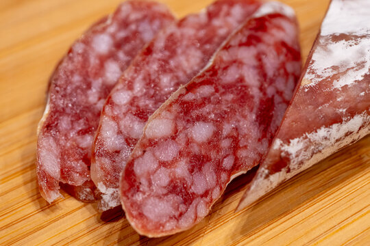 Sliced fuet sausage on wooden board closeup