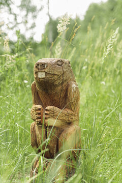 Funny wooden beaver or marmot sculpture carved from log in field