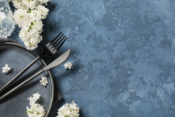 Obraz premium Beautiful table setting with white lilac flowers on blue background