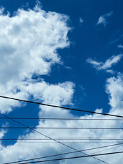 Fototapeta premium Clear Blue Sky With White Clouds and Wires