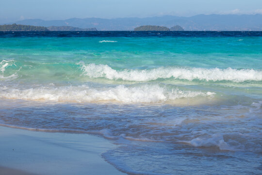 Turquoise Waves Washing Ashore on Sandy Beach