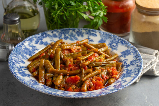 Traditional Turkish green beans stew cooked with tomatoes and olive oil on a ceramic plate