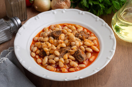 Top view of traditional turkish kuru fasulye white bean stew with meat in a ceramic bowl