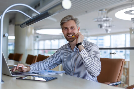 Smiling friendly handsome young male call centre operator.