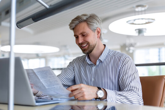 Portrait of successful businessman office worker looking camera holding tablet computer in hands, online customer service, wearing headset for video call, satisfied with work