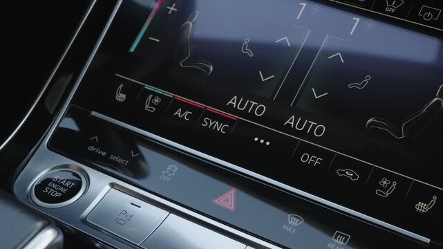 Close-up of female hand pressing touchscreen button to turn on seat ventilation system inside modern luxury car cockpit.