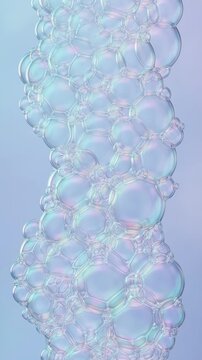 Vertical video of a column of iridescent soap bubbles. Shimmering foam texture on a soft blue gradient background. Liquid forms concept