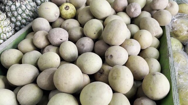 Fresh sapodilla fruits piled up at traditional market