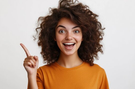 person with curly dark hair and blurred face in orange shirt pointing upward with index finger against plain white background, conveying a thoughtful idea and assertive gesture