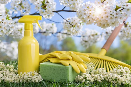 The Yellow Spray Bottle with Cleaning Gloves and Sponge in Blooming Garden