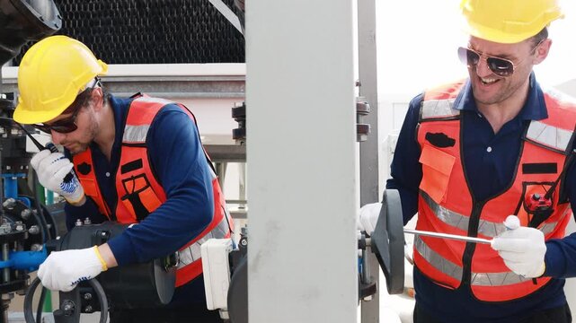 Team male technicians working HVAC water cooling systems inspects water pipe connections cooling tower circulation (Evap) systems efficient technology checks leaks combination wrench tighten nuts.
