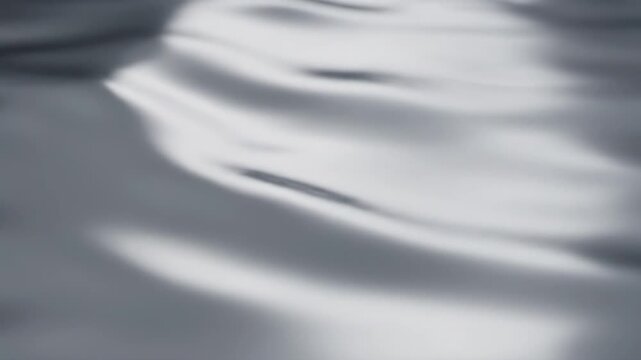 Elegant abstract waves of liquid surface gently catching soft light and shadow, creating a dynamic yet peaceful visual texture and tranquil atmosphere