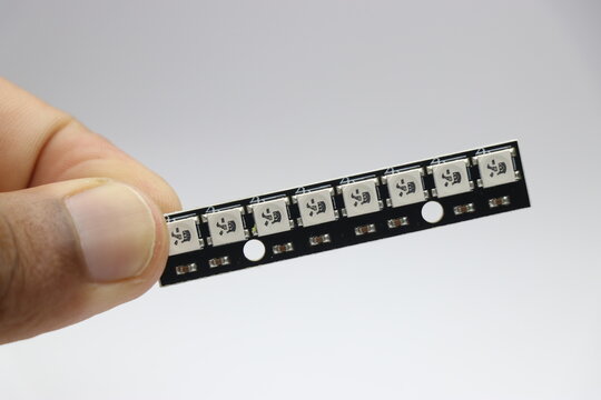 ws2812b led strip with individually addressable LEDs held in the hand on white background