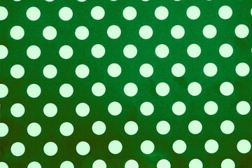Green polka dot pattern background. White dots on green wallpaper texture. Abstract decorative design element © Iqra