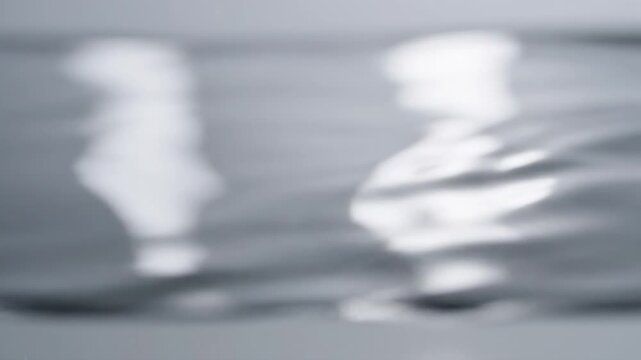 Abstract Soft Silver Liquid Reflections and Blurred White Light Patterns on a Clean Minimalist Background