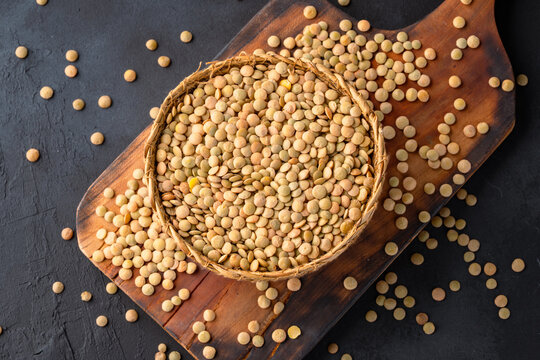Uncooked green  lentils on black stone background	