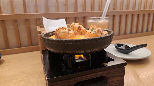 Baked Salmon Sushi Rolls Sizzling on Hot Plate with Sauce