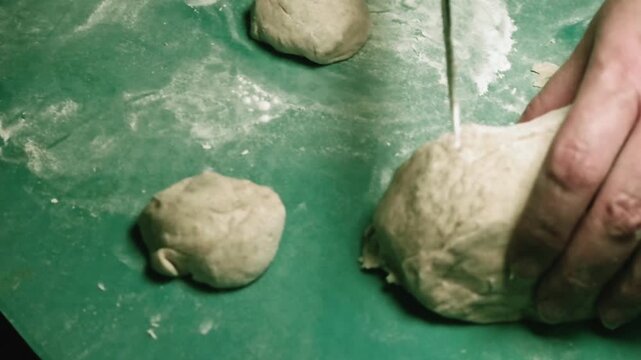 Artisanal Bread Making Process: Close-Up Look Of Flour-Dusted Dough Balls On Vibrant Green Work Surface