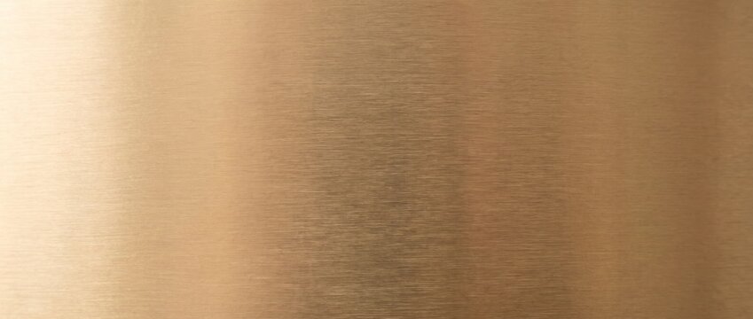 Brushed brass metal texture background with fine grain and warm golden sheen