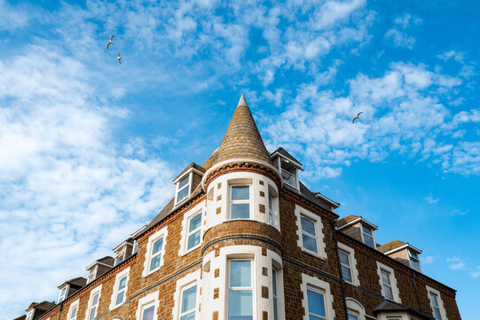 Exterior view of luxury apartments showing the contemporary design and conical roof line. Seen on the British coastline.