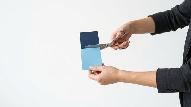 Cost cutting, budget reduction, business decision concept with scissors slicing blue block.
