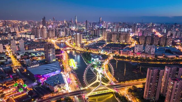 Aerial night timelpase of the Tianjin Eye Ferris wheel over the Haihe River in Tianjin, China