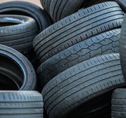 Obraz premium Close view of stacked discarded tires with chalk markings.