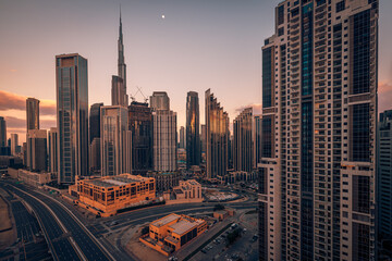 Obraz premium Stunning Dubai skyline, modern skyscrapers, aerial city view, golden sunset. Futuristic urban architecture, luxury UAE cityscape. Business travel destination background, modern city wallpaper design