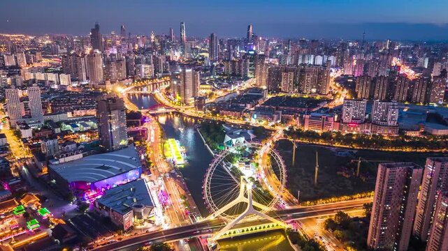 Aerial night timelpase of the Tianjin Eye Ferris wheel over the Haihe River in Tianjin, China