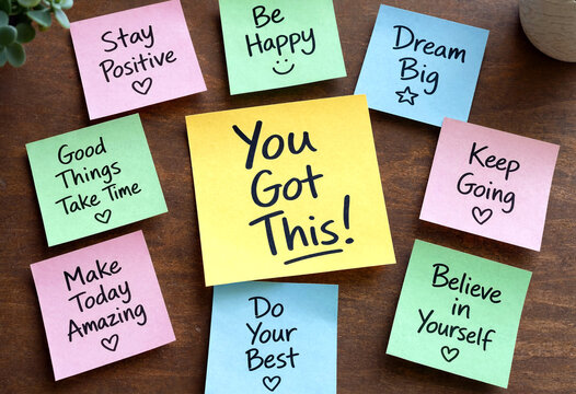 Colorful motivational sticky notes on wooden table with encouraging messages and positive affirmations for inspiration