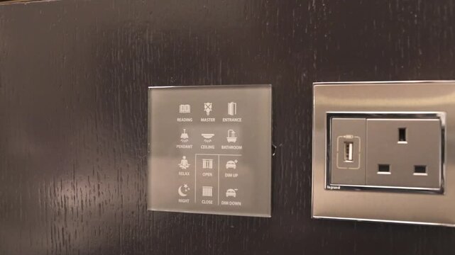 Close-up of a modern hotel smart touch control panel and luxury electrical power outlet with USB charging port.