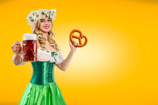 Oktoberfest girl holding pretzel, beer mug. Woman in dirndl, wreath of daisies. Isolated background. Traditional Bavarian, German, Austrian party, autumn festival.