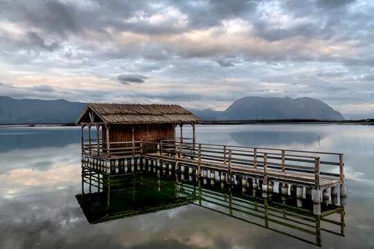 Beautiful colors in  Mesolongi lagoon - A traditiunal, wooden fishing hut and its reflection on the blue water under a beautiful sky