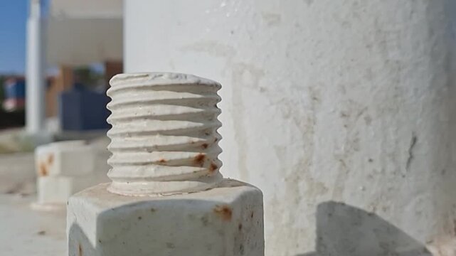 Rusty bolt and nut on white painted metal structure