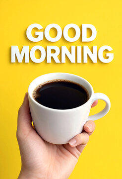 Hand holding a white coffee cup with black coffee and good morning text above