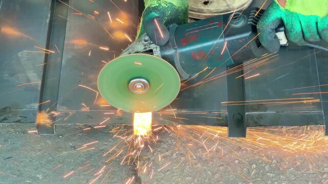 angle grinder cutting sheet metal, producing brilliant shower of friction sparks.