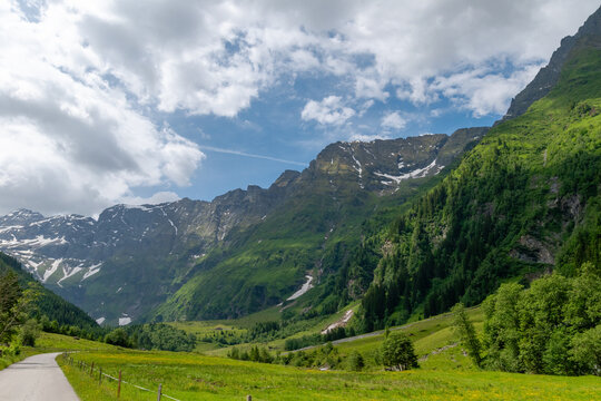 Green alpine valley with lingering snow near Mittersill