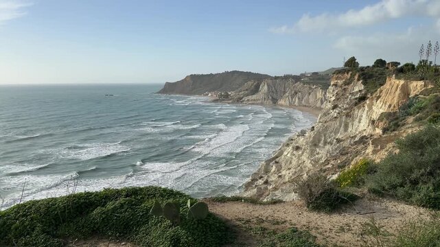 Scala dei Turchi. Realmonte, Sicily. Coastal landscape featuring white cliffs and rolling waves under a clear blue sky, showcasing the natural beauty of the shoreline and ocean in a serene environment