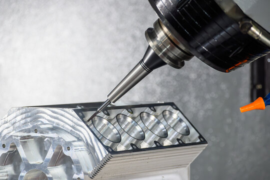 High-precision 5-axis CNC milling machine performing a finish cut on an aluminum V8 engine block with a flat nose end mill tool.
