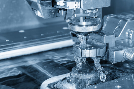 vHigh-precision wire EDM machine cutting process on a metal mold part in a blue tone scene.