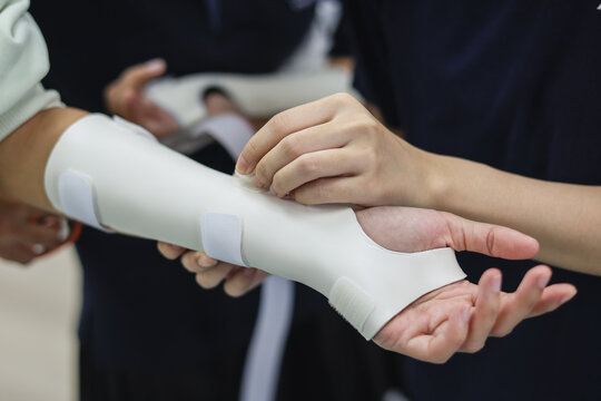 Medical professional custom thermoplastic wrist splint on a patient's arm for hand rehabilitation in a clinic, orthopedic and occupational therapy treatment concept.