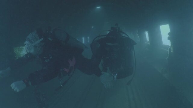 log footage of an airplane wreck underwater scuba divers to explore  metal on ocean floor