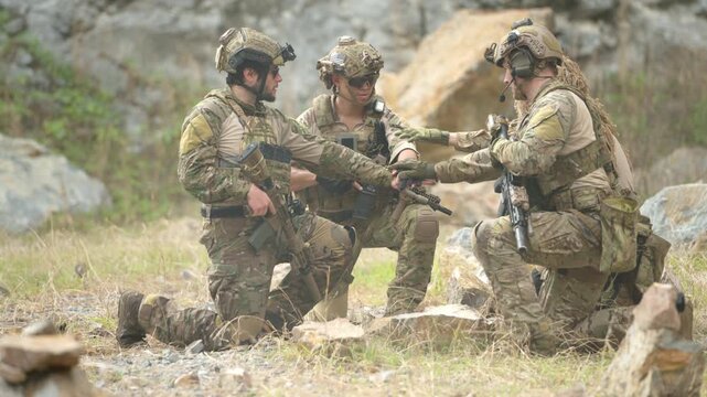 Military personnel conduct a tactical briefing and mission coordination meeting during a field training exercise
