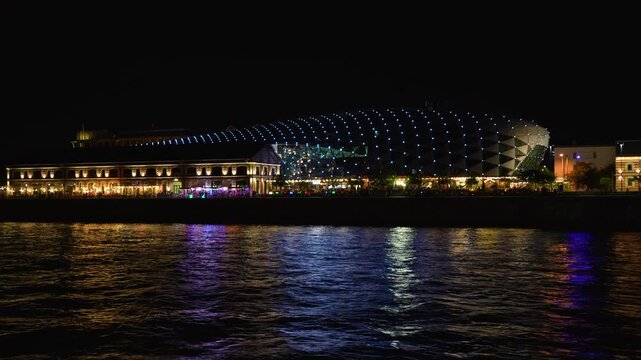 Elegant Night Cityscape of B&aacute;lna Budapest (Whale Building): Stunning illuminated modern architectural landmark and historic warehouse along the Danube Riverbank at night