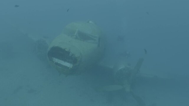 log footage of an airplane wreck underwater scuba divers to explore  metal on ocean floor
