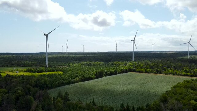 Aerial wide shot of Kent Hills wind farm in New Brunswick, Canada. Wind turbines generating renewable green energy in rural landscape